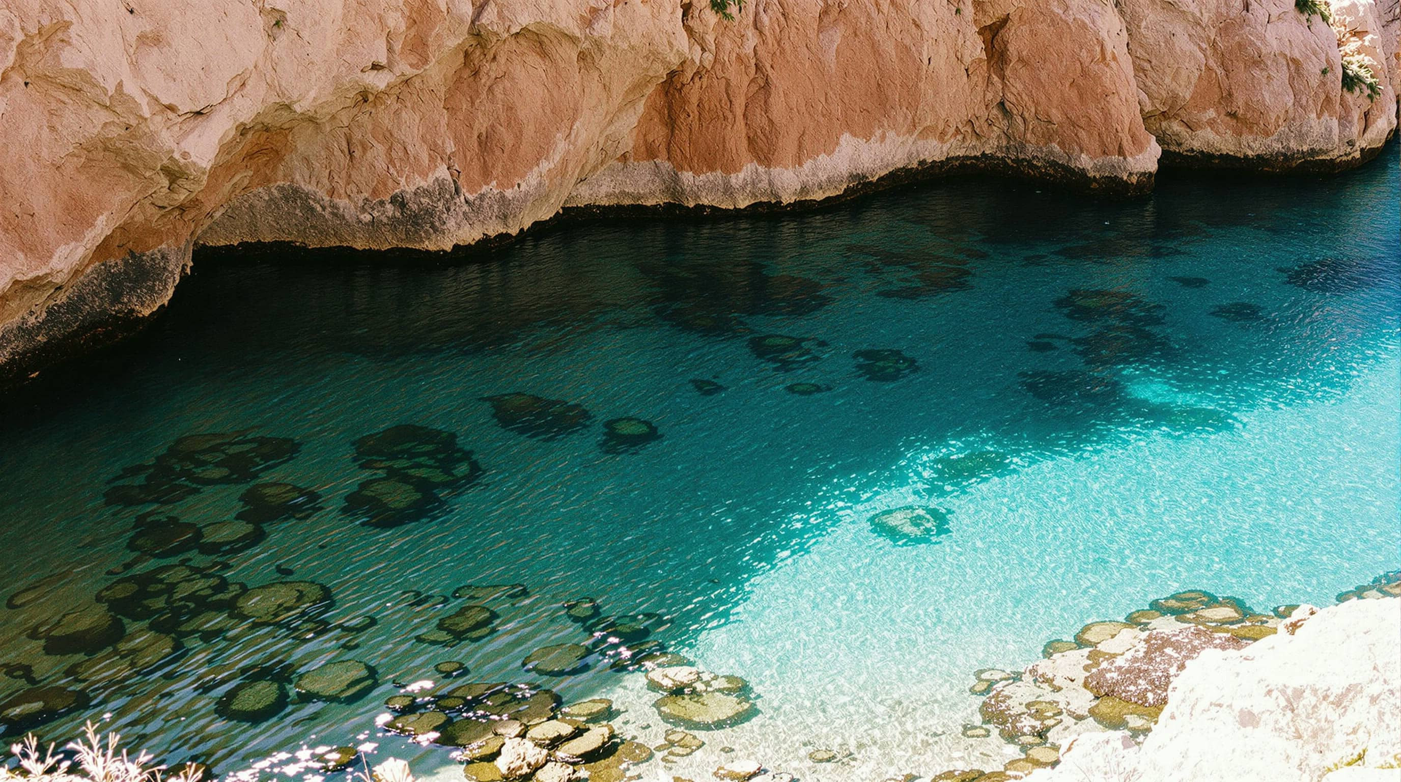 A sheltered granite cove on the Costa Smeralda in calm water.